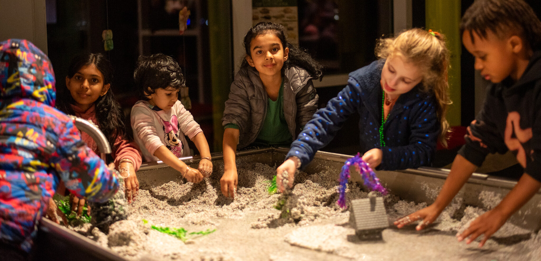Kids playing at a sand table at LCM